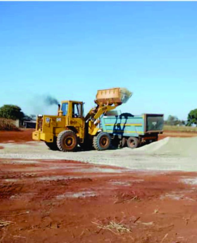 Front-end loader filling a truck with aggregate.