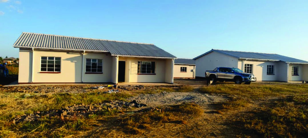 Completed camp houses with a grader working the access road, Dotito.